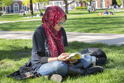 student reads on quad