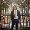 Noah Meyerhoff stands on a indoor balcony